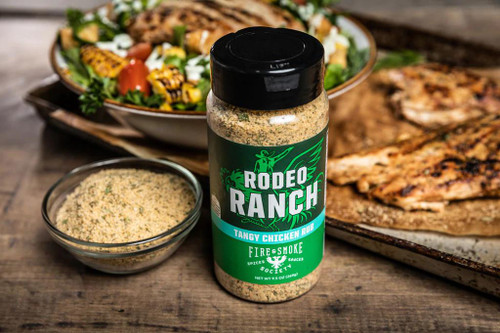 Fire & Smoke Society F&S RODEO RANCH CHICKEN RUB 9.5 OZ, spice rub container for grilling and barbecue on a wooden table with cooked chicken, salad, and grilled vegetables in the background.