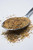 Fire & Smoke Society F&S | The Usual All-Purpose Spice 10.7 oz, ground spice mix with herbs and spices scattered on a white surface with a metal spoon.
