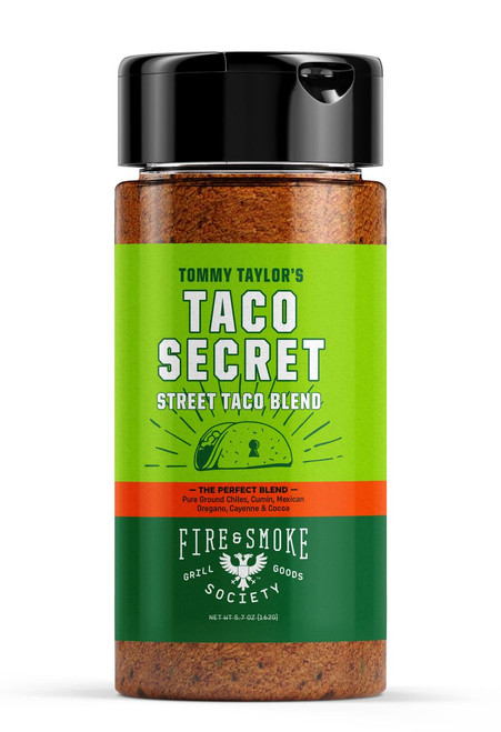 Fire & Smoke Society F&S | Tommy Taylor's Taco Secret Taco Seasoning 9.2 oz, front view of the seasoning bottle with a green label, black lid, and textured brown spice inside the transparent bottle.