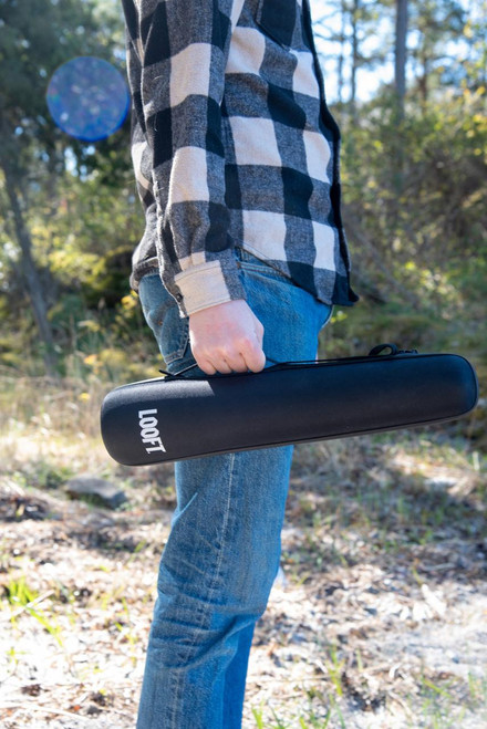 Looft Lighter X Case, portable black carrying case with the brand name Looft printed on it, held by a person outdoors in a forest setting.
