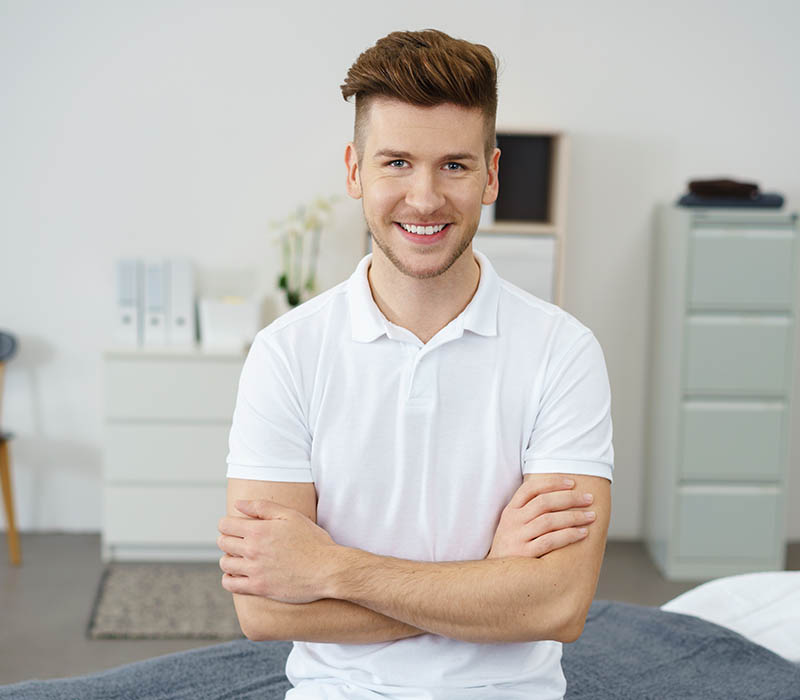 Handsome Male Therapist Sitting on Therapy Bed