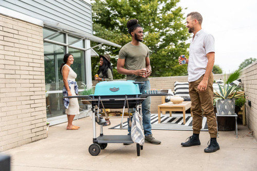 PK Grills The All New Original PK300AF Grill & Smoker - Teal, outdoor gathering with friends on patio.