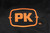 PK Grills The All New PK360 Slim Cover, close-up view of the embroidered logo on the black grill cover showcasing the orange stitching and branding.