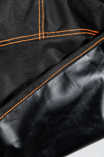 PK Grills The All New PK360 Slim Cover, close-up of black fabric material with orange stitching detailing.