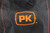 PK Grills The NEW PK300 Slim Cover, close-up of the black grill cover with orange PK logo patch.