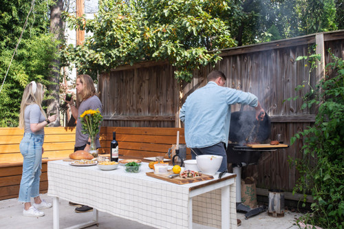 PK Grills The PK360 Grill & Smoker - Classic Silver, outdoor BBQ grill with a round shape and silver finish, being used for grilling in a backyard setting.