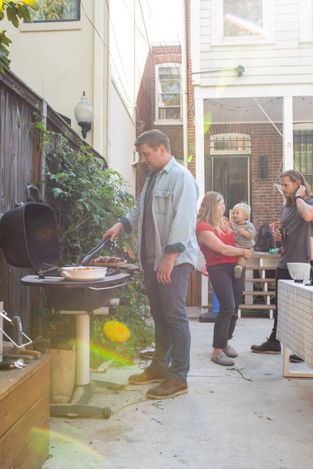 PK Grills The PK360 Grill & Smoker - Classic Silver, outdoor backyard scene with people enjoying a barbecue gathering.