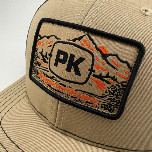 PK Legend Khaki Hat, close-up of khaki baseball cap with embroidered logo patch featuring mountains, sunset, and the slogan 'The Legend and The Legacy'.
