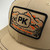 PK Legend Khaki Hat, close-up of khaki baseball cap with embroidered logo patch featuring mountains, sunset, and the slogan 'The Legend and The Legacy'.