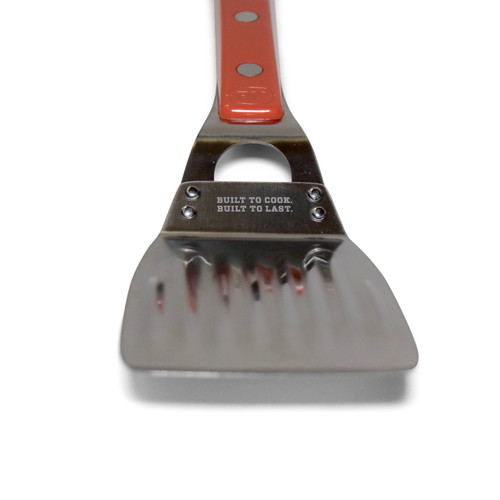 The Stainless Steel PK Spatula, a durable kitchen utensil with a sturdy stainless steel blade and a red handle for flipping and serving food.